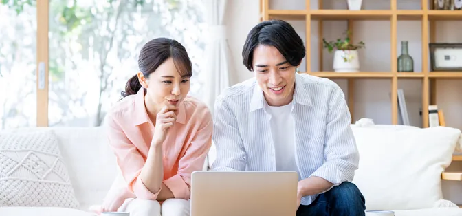 ノートパソコンを見ながら相談する新郎新婦