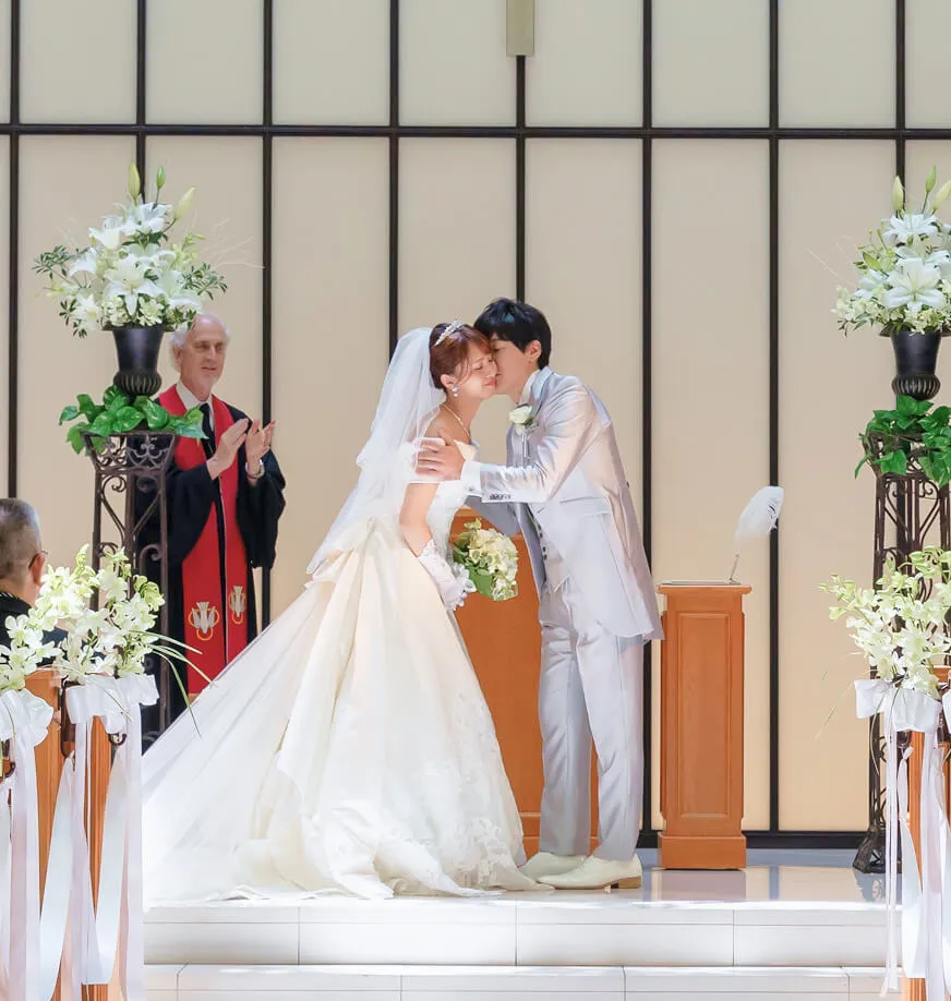 結婚式で新郎が新婦の頬にキスをする様子